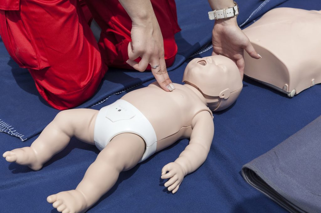 CPR being performed on a baby resuscitation dummy
