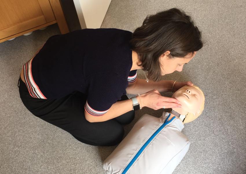 Woman clears airway on a resuscitation dummy
